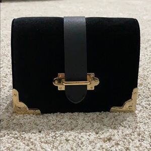Suede black purse with gold metal designs.